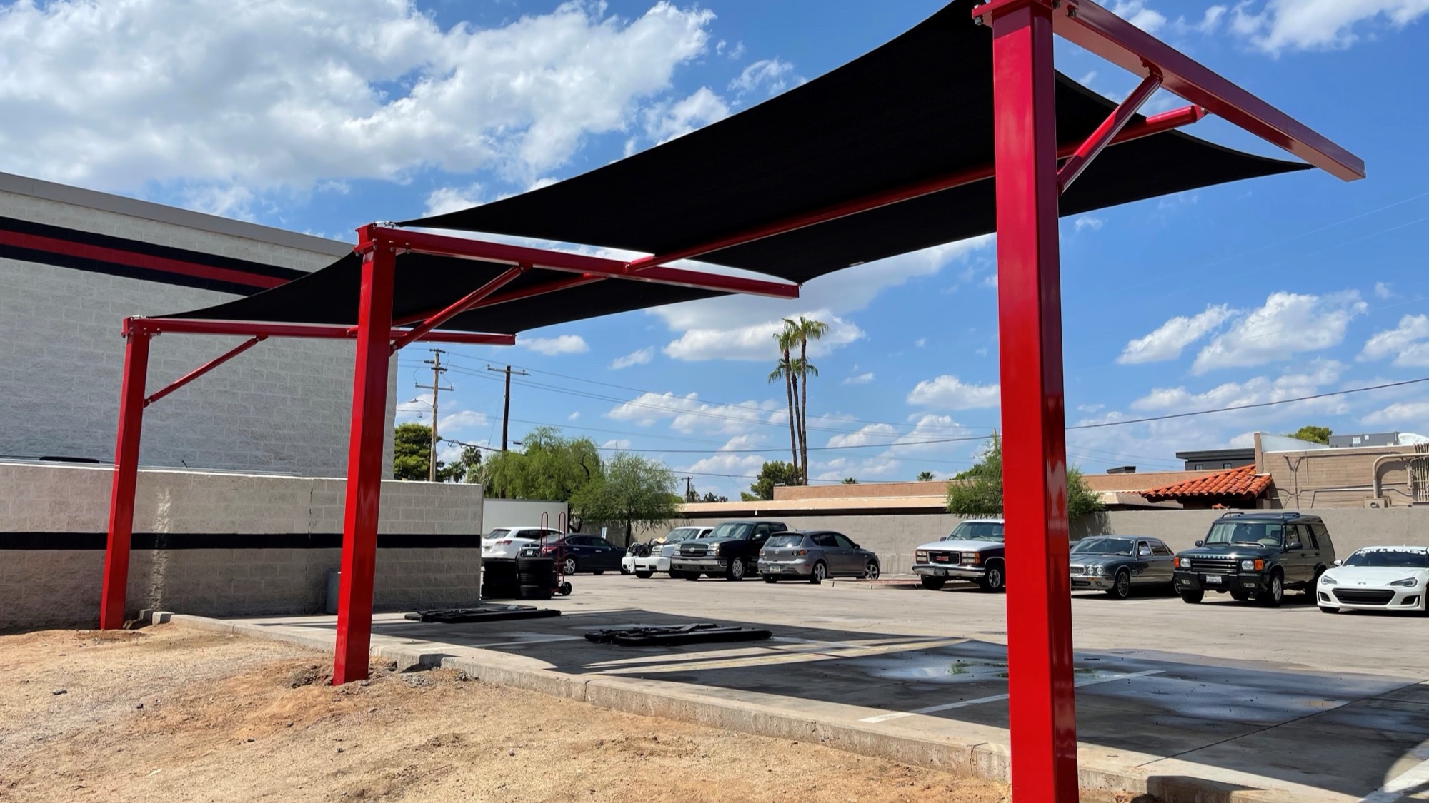 Cantilever shade structure providing column-free coverage over a commercial property drive lane