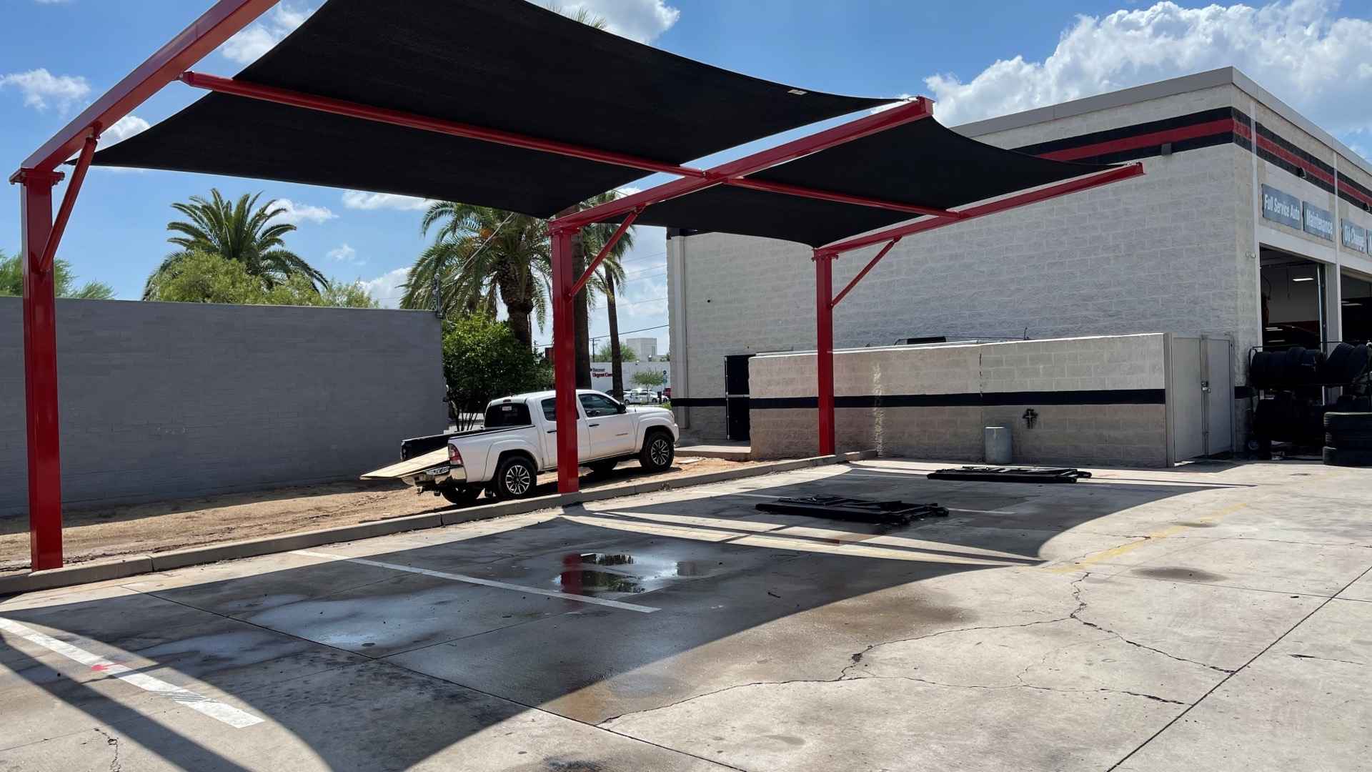commercial-parking-lot-shade-structures Commercial parking lot shade structure with red cantilever canopy over a covered vehicle