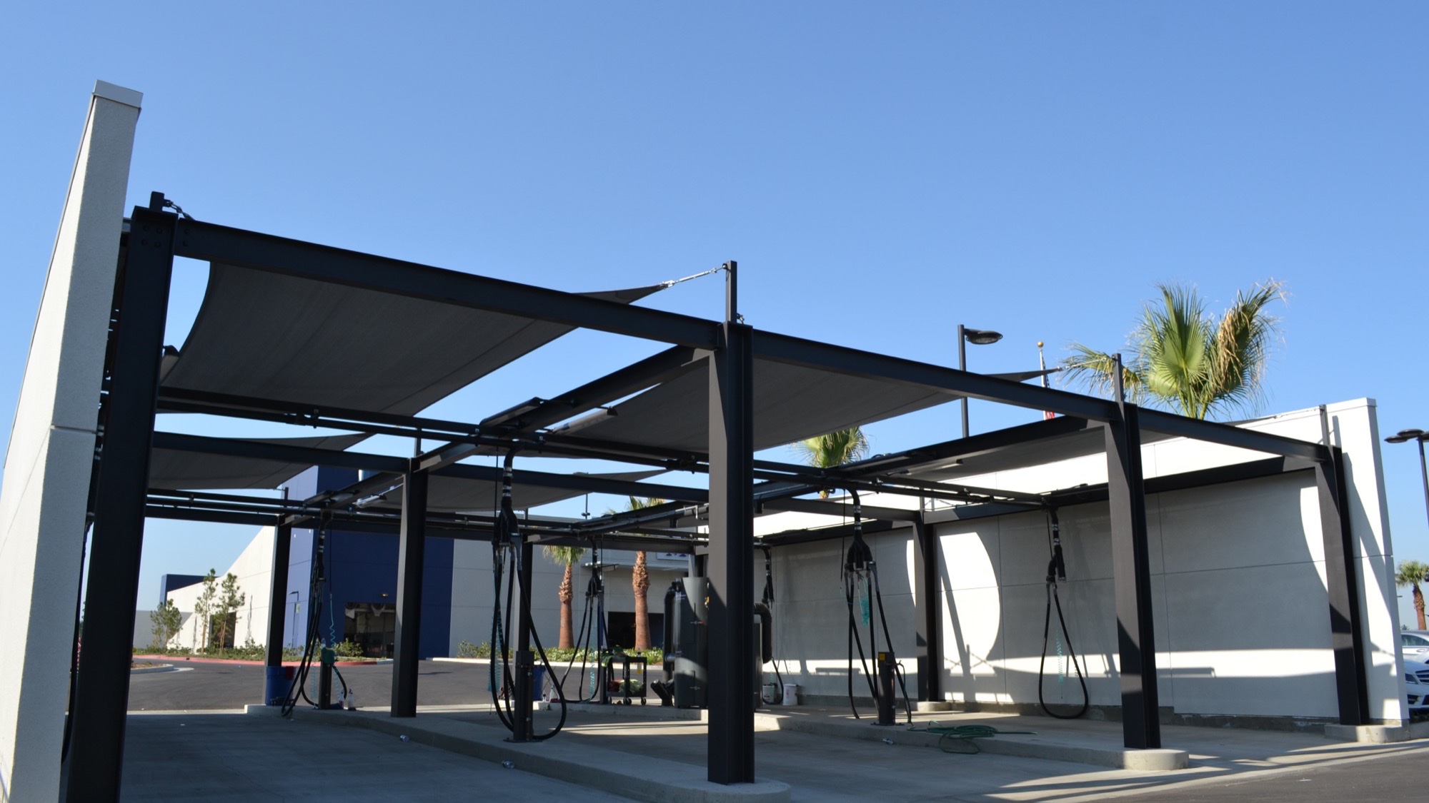 Steel-framed police fleet parking canopy shading a row of vehicles at a secure commercial lot