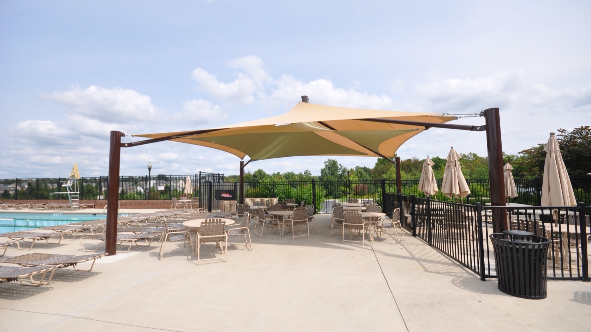 Pool shade structures over a resort-style pool deck at a hotel and HOA community