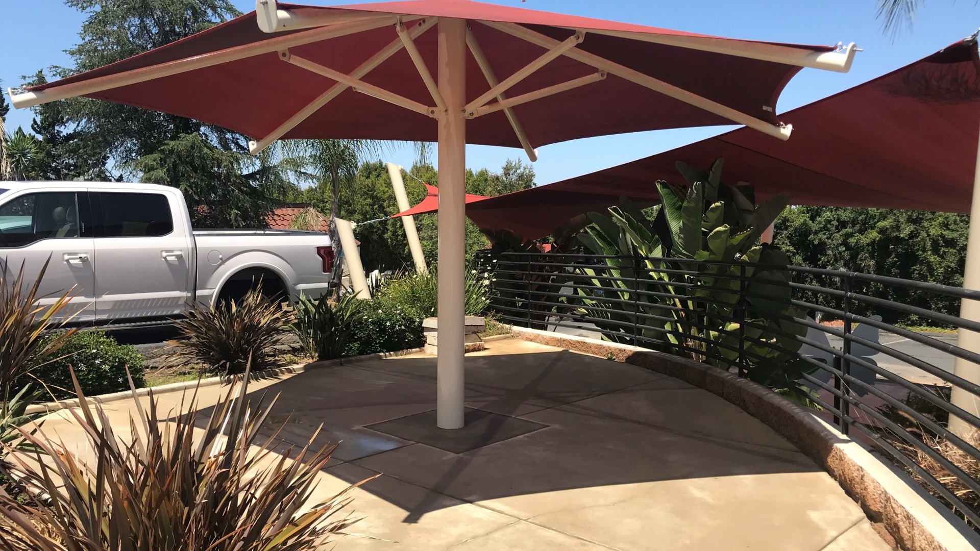 Shade structures for apartment communities providing courtyard shade over a resident patio