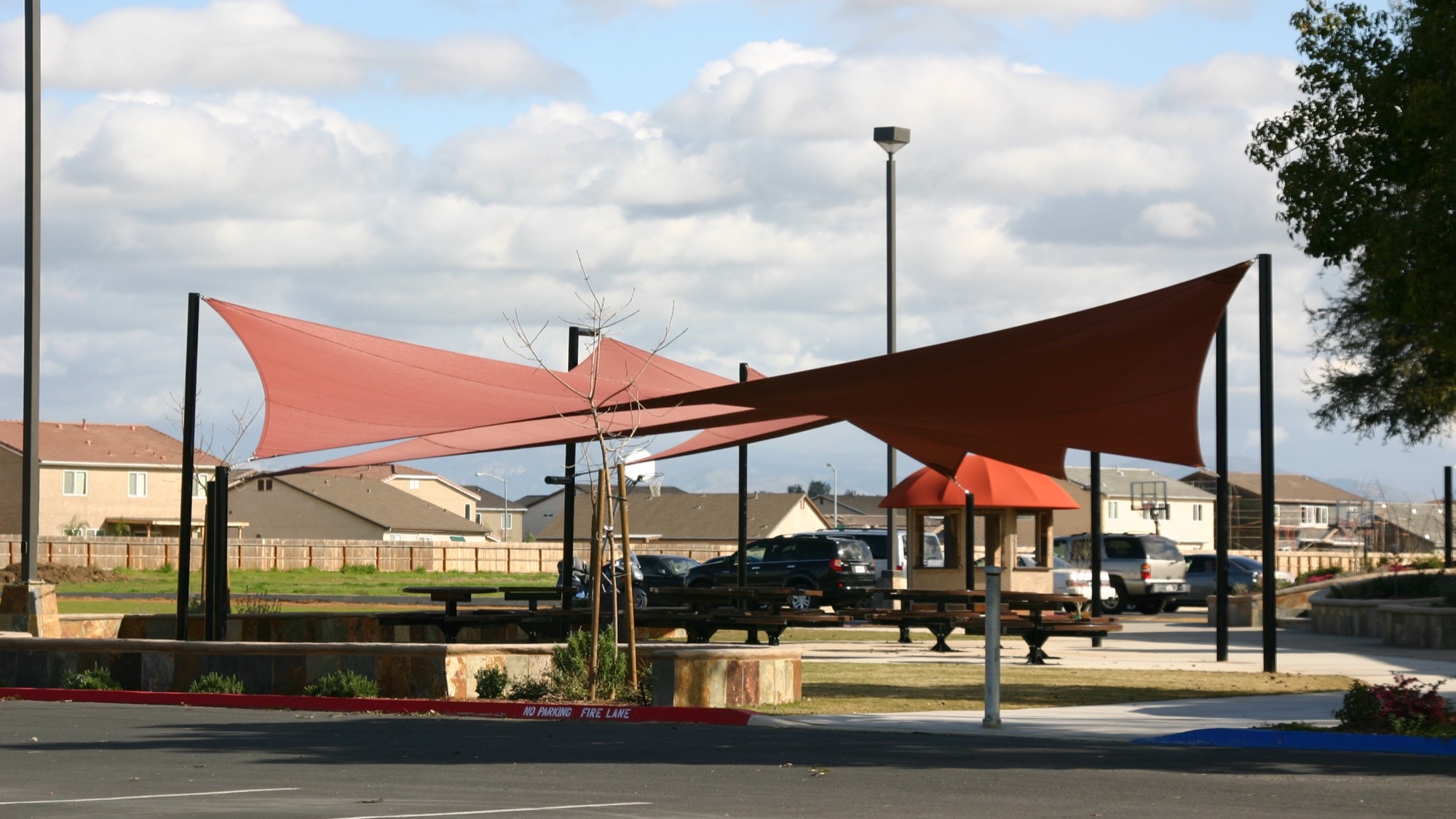School Lunch Shelter Canopies – Custom Canopies Inc. School lunch shelter canopy with shade sails covering picnic tables and a serving kiosk on a campus courtyard
