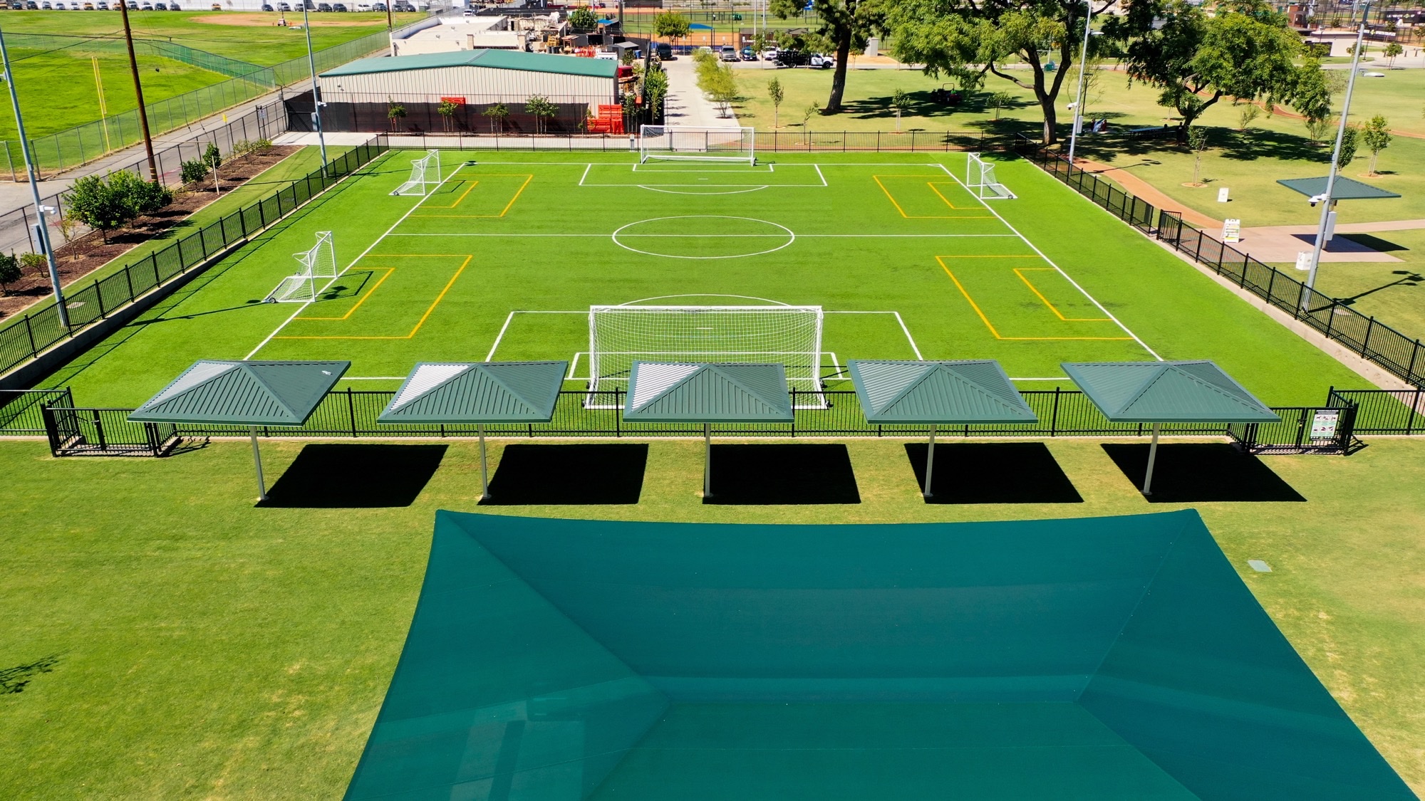 Vandal Resistant Shade Structures Vandal resistant shade structures with steel hip canopies over a municipal park seating area