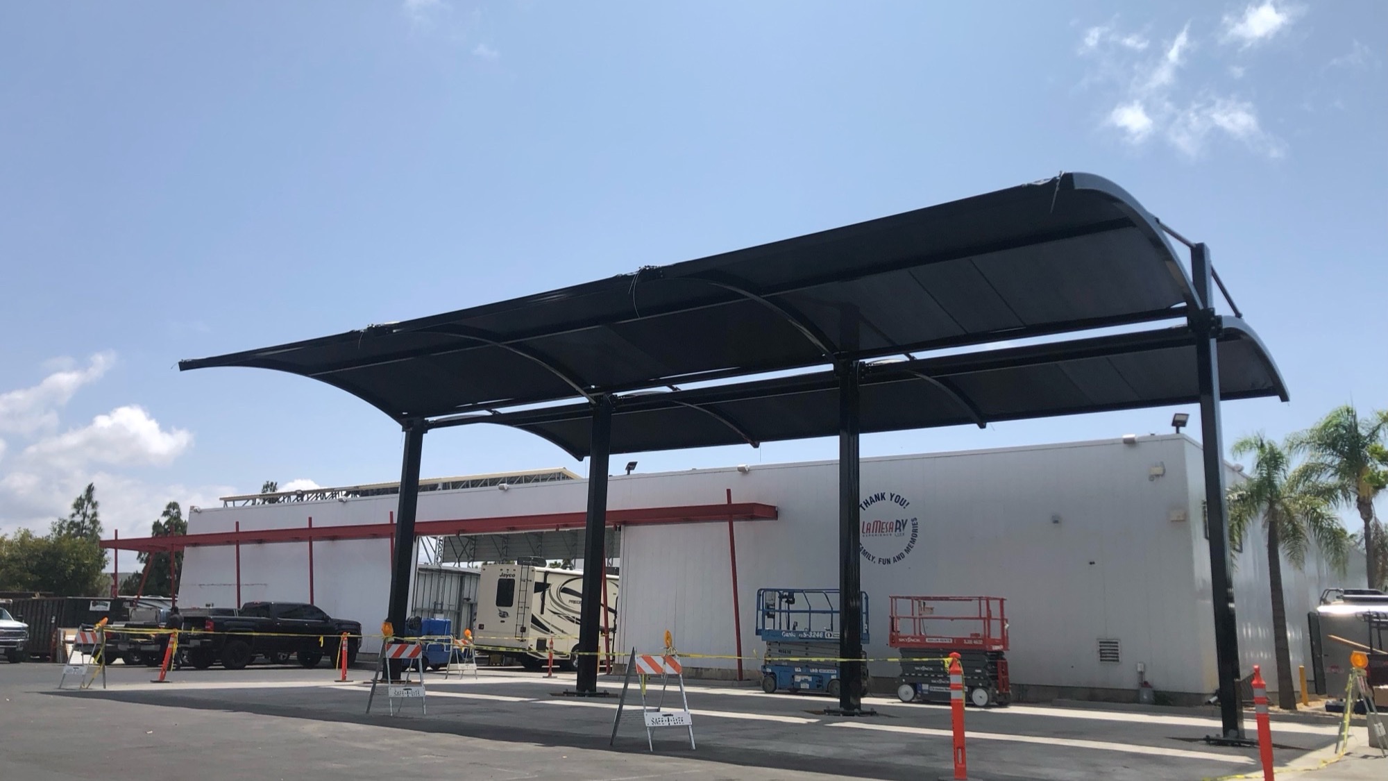Auto dealership display lot canopies shading vehicle inventory at an RV dealership