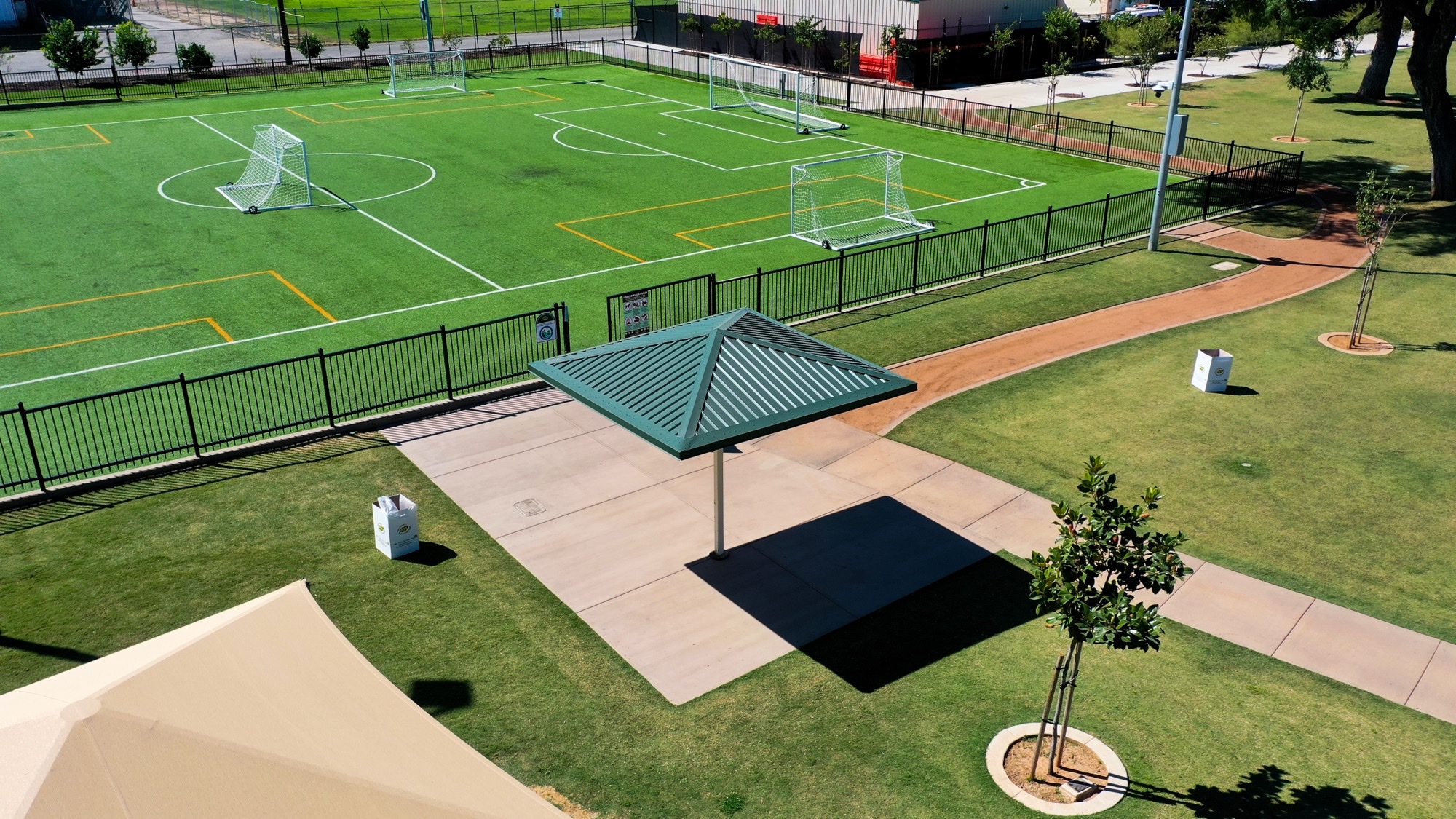 Shade Structures for Turf Fields Cantilever hip canopy at the sideline of a synthetic turf soccer field, an example of shade structures for turf fields